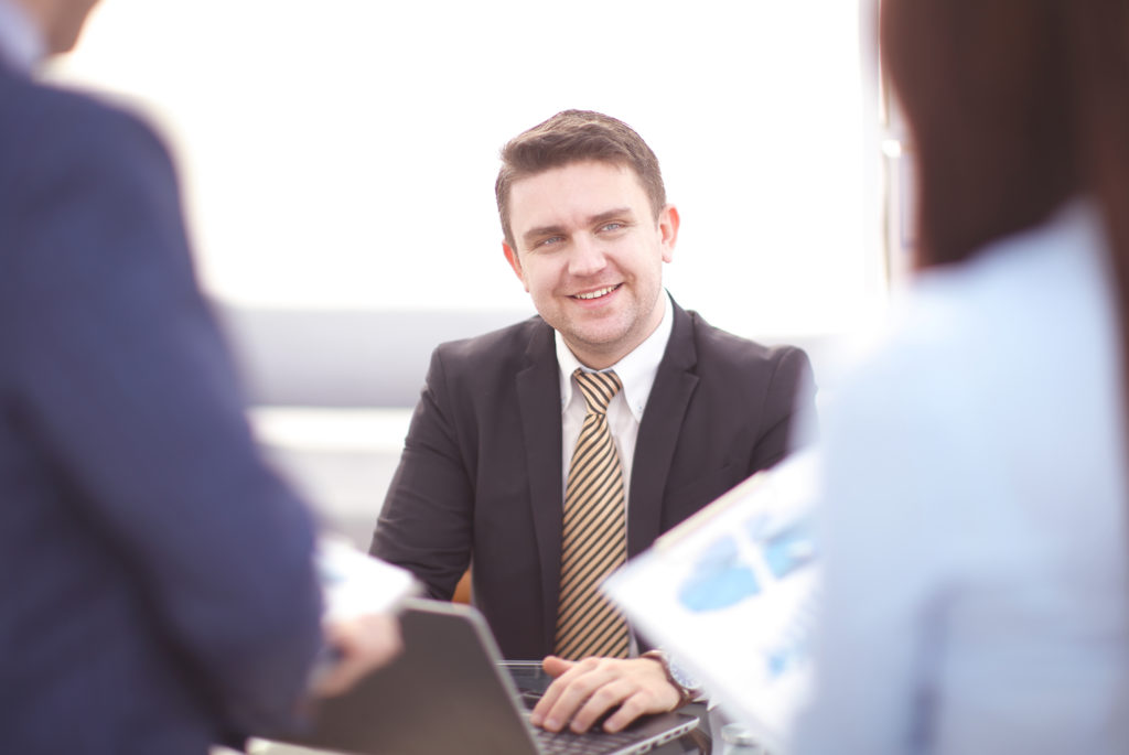 Happy smart business man with team mates discussing